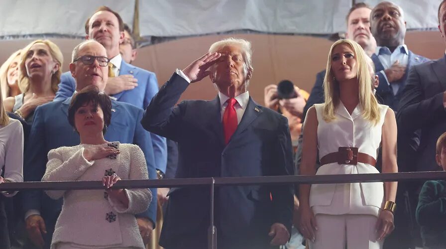 Donald Trump salutes in stands during Super Bowl LIX, receiving loud applause from fans