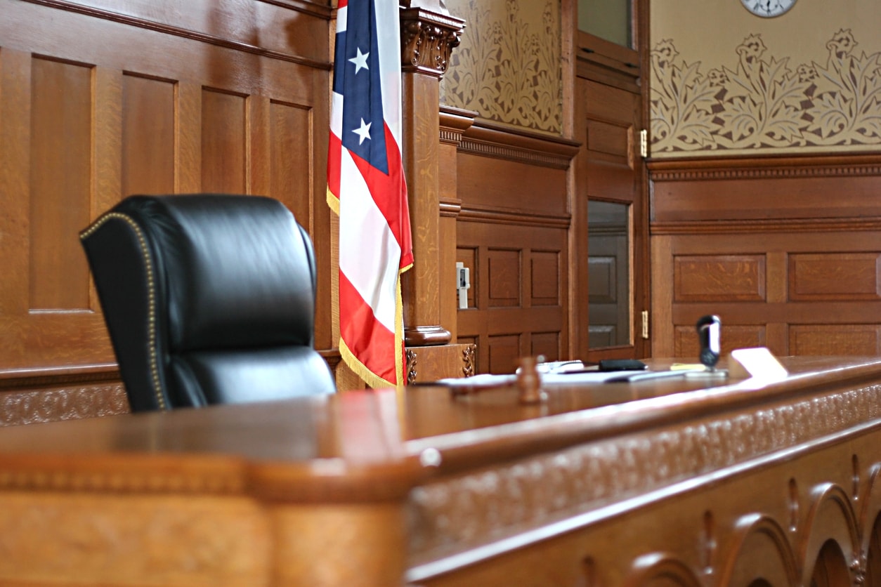 empty courtroom in new mexico with judge bench and flag