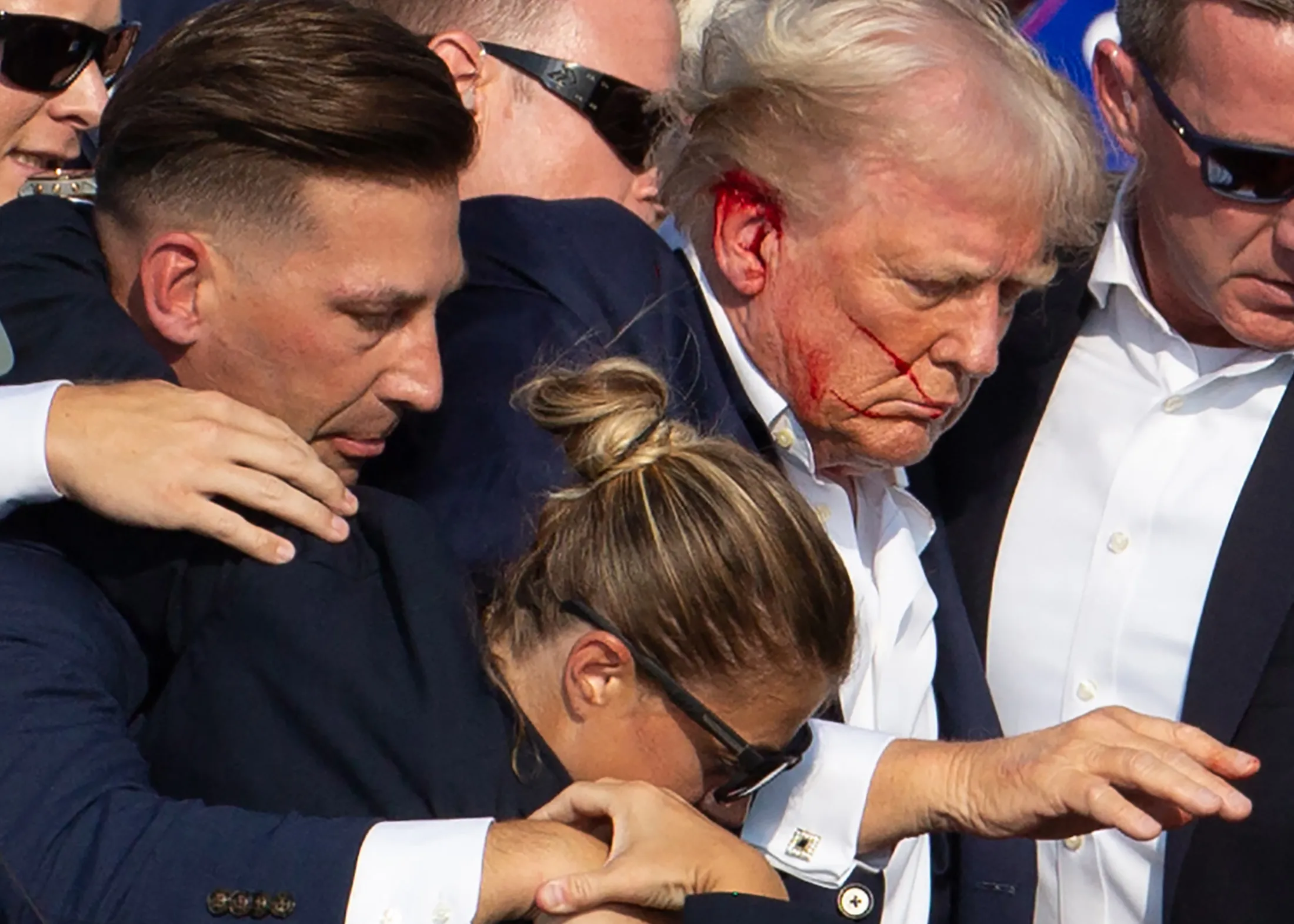 President Trump with blood on his face surrounded by Secret Service, moments after the shooting