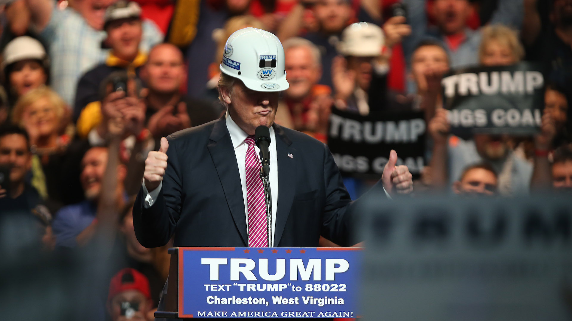 President Trump addressing workers at a U.S. copper mine, American flags waving, with miners cheering