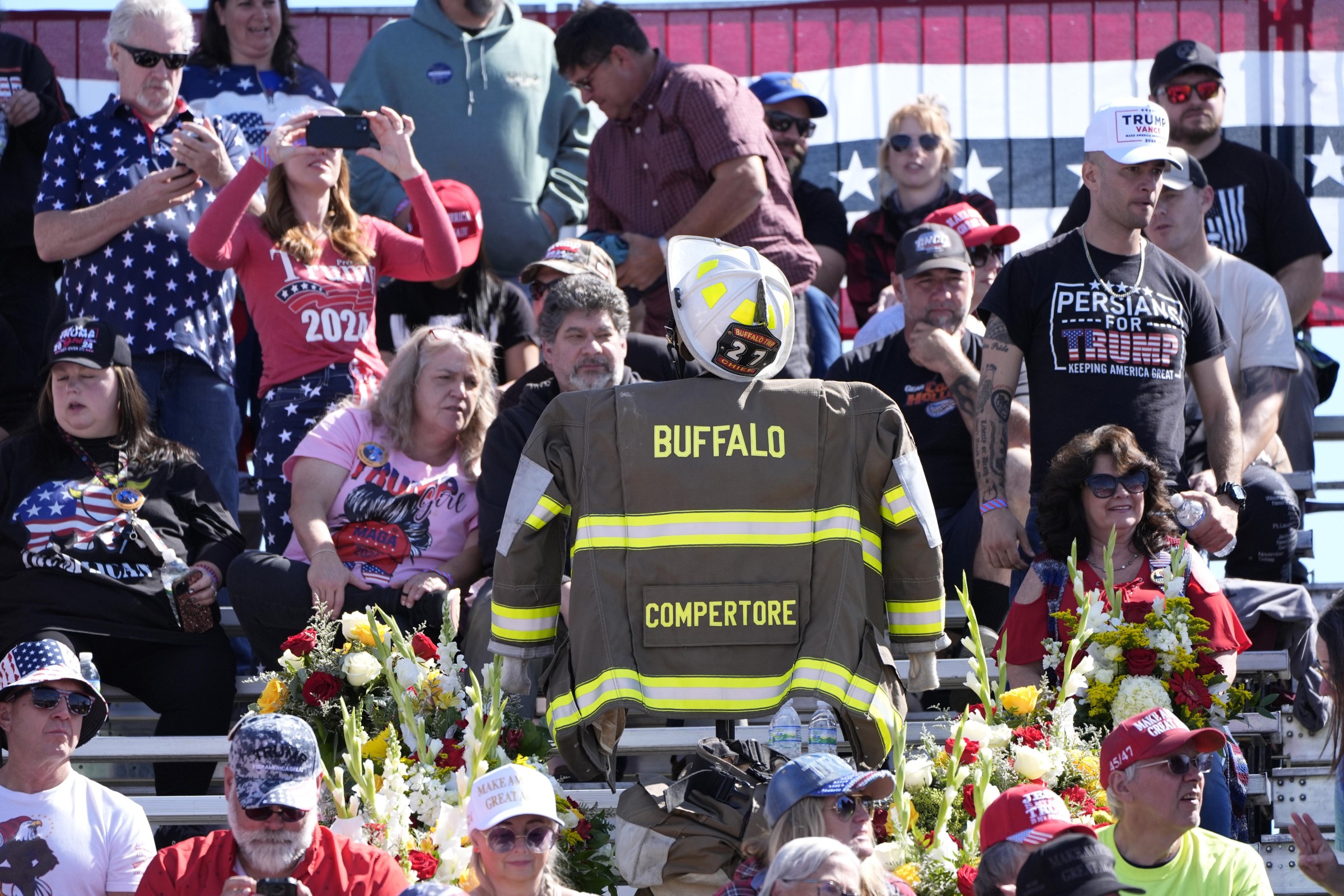 Memorial at Butler, Pennsylvania rally site with Trump supporters honoring Corey Comperatore and celebrating Trump’s survival