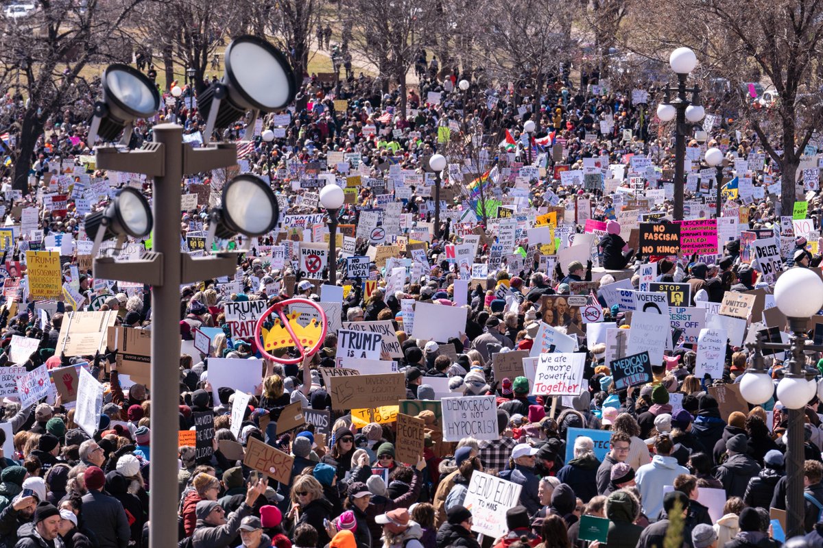 Protesters holding signs saying “Protect Women’s Sports” and “Truth Matters”