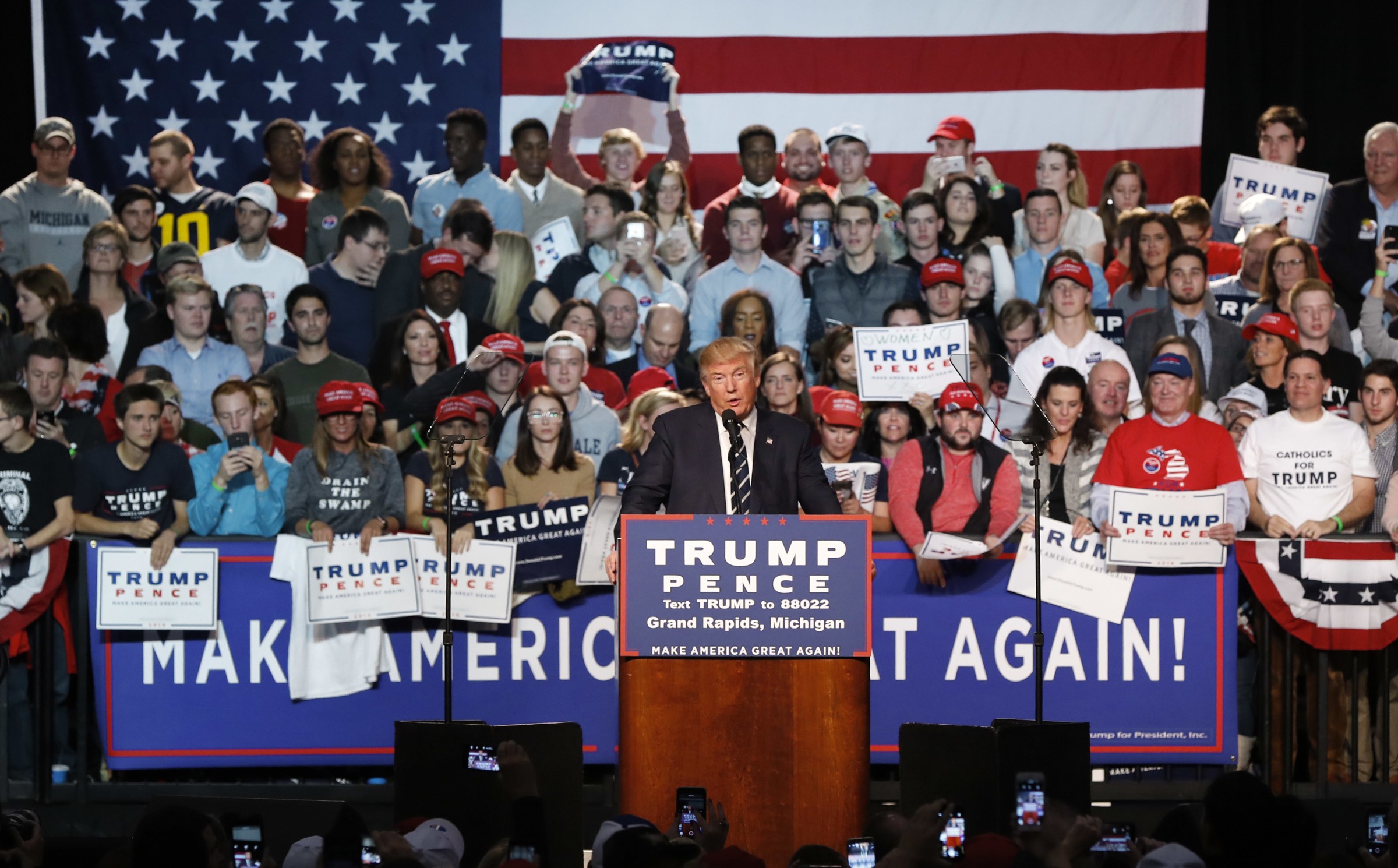 Trump rally with crowd holding "Drain The Swamp" and "Justice For All" signs