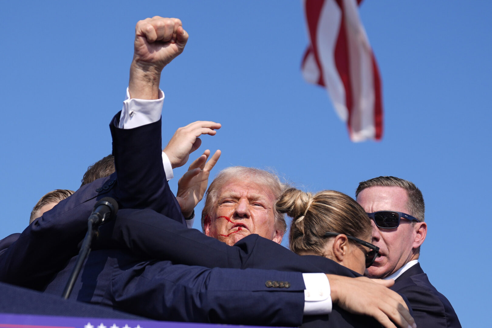 donald turmp raising his fist after being shot in butler