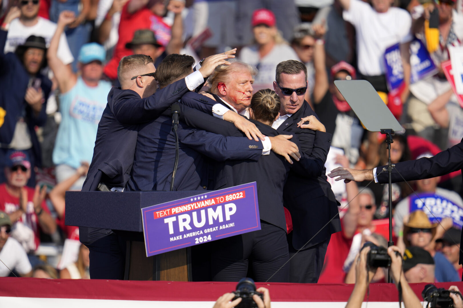 A silhouette of trump on stage at rally